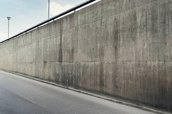 Muro di cemento e strada asfaltata — Foto Stock
