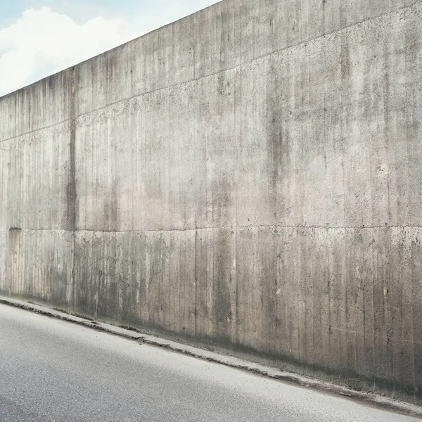 Betonnen muur en asfalt weg — Stockfoto