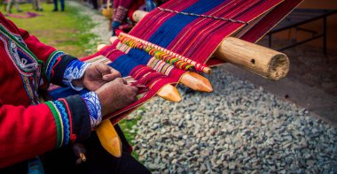 Hands weaving traditional blanket Chinchero clipart