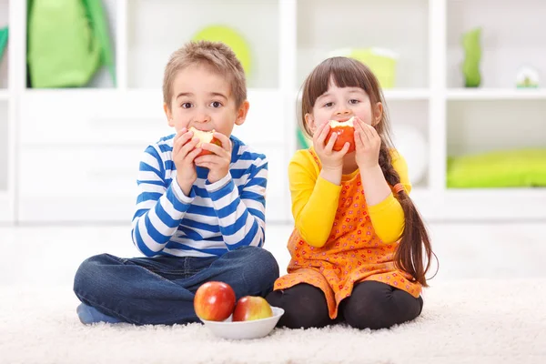 Kleine jongen en meisje eten van appels — Stockfoto