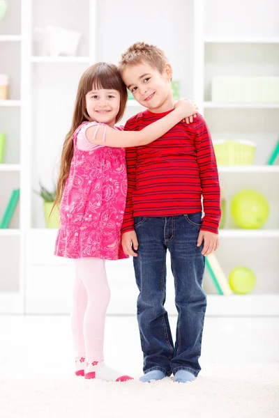 Kleine Schwester umarmt ihren Bruder — Stockfoto