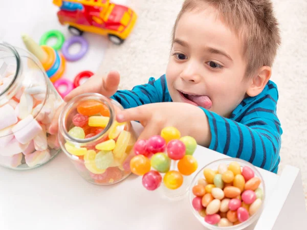 Маленький мальчик берет слишком много конфет — стоковое фото