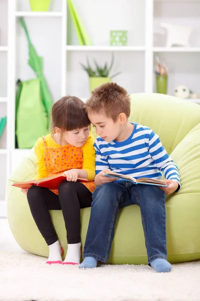 Little girl and boy reading Stock Picture