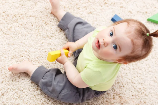 Pequena menina no meio de brinquedos — Fotografia de Stock