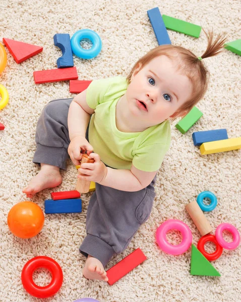 Pequena menina no meio de brinquedos — Fotografia de Stock