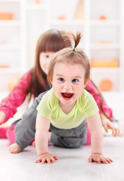 Krypande pigtailed småbarn flicka som leker — Stockfoto