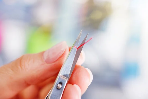 Seamstress cutting the thread with scissors — Stock Photo, Image