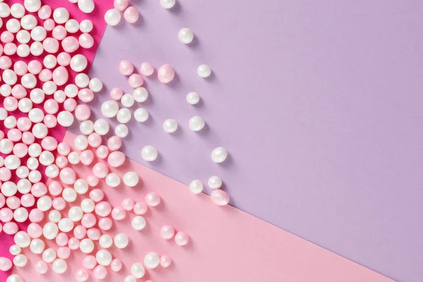 Zuckerbonbons auf pastellfarbenem Hintergrund verstreut — Stockfoto