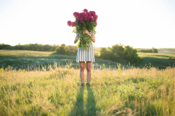 Femme avec grand bouquet de pivoines rouges — Photo