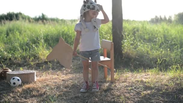 Kid i roliga djur hatt spela med trä leksak häst — Stockvideo