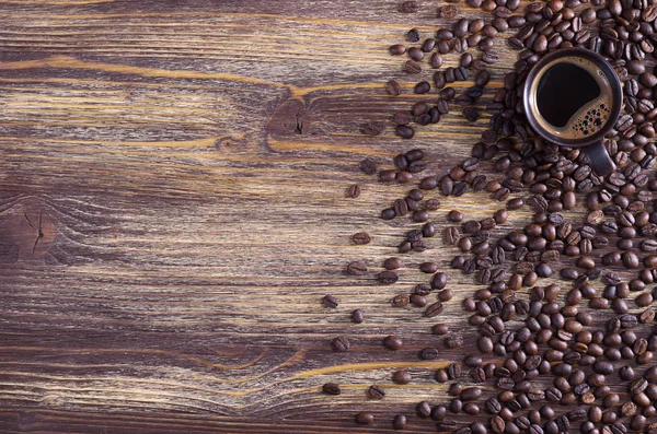 Xícara de café e grãos espalhados — Fotografia de Stock