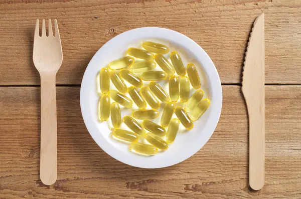 Omega3 kapsülleri tabak ve çatal bıçak takımları — Stok fotoğraf