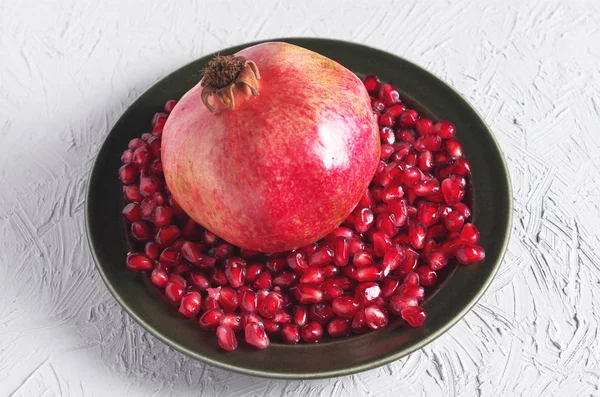 Pomegranate and seeds in plate — Stock Photo, Image
