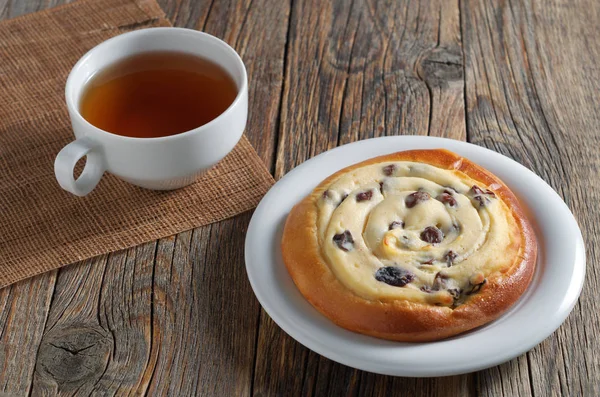 Bun with cottage cheese and tea — Stock Photo, Image