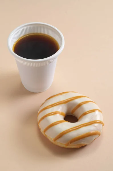 纸盘和咖啡杯上的甜甜圈 浅褐色底色 — 图库照片