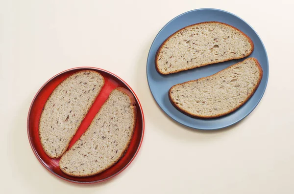 ベージュの背景にパンのスライスを持つ2つのプレート トップビュー — ストック写真