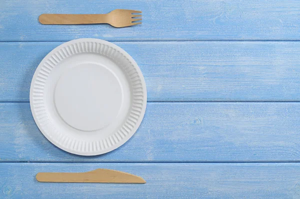 木製のナイフで紙皿と青いテーブルの上にフォーク テキストのためのスペースとトップビュー — ストック写真