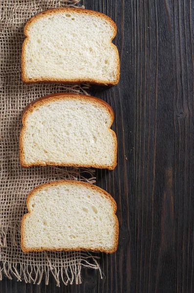 Tři Plátky Pšeničného Chleba Černém Dřevěném Stole Pohled Shora — Stock fotografie