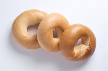 Beyaz arkaplanda taze klasik simit. Yakın plan, üst görünüm.