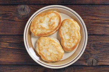 Eski ahşap arka planda, tabakta kızarmış gözleme.