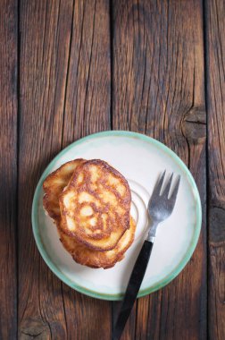 Tahta masadaki tabakta bir yığın kızarmış krep, fotokopi alanı olan üst manzara.
