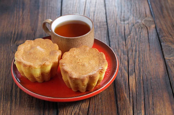 Kopje Thee Twee Heerlijke Muffins Een Rode Plaat Houten Tafel — Stockfoto