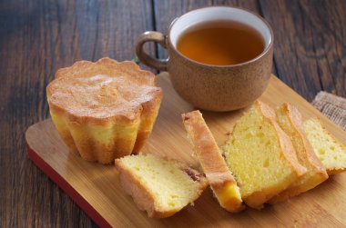 Koyu ahşap masa üzerinde kesme tahtasıyla kesilmiş çörekler.