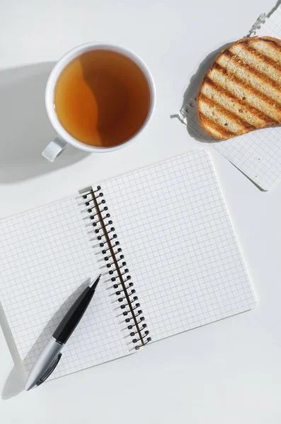 Quaderno Aperto Con Penna Tazza Pane Alla Griglia Tavolo Bianco — Foto Stock