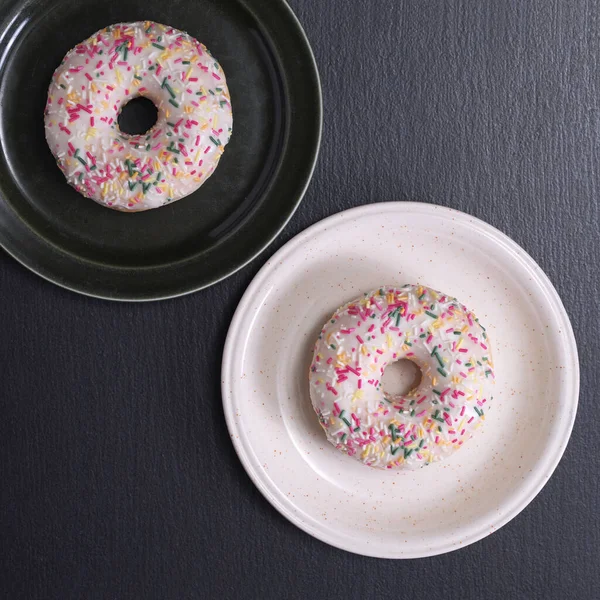 Dois Donuts Com Cobertura Polvilhas Uma Placa Sobre Fundo Pedra — Fotografia de Stock