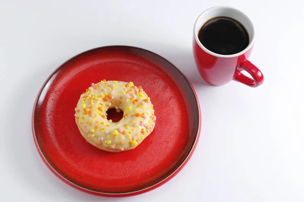 Ciambella Con Glassa Spruzzi Piatto Rosso Una Tazza Caffè Sfondo — Foto Stock