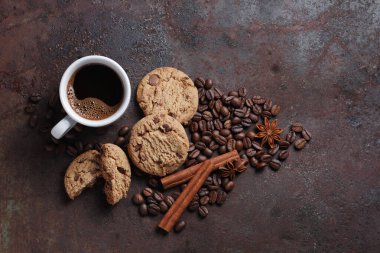 Bir fincan kahve ve çikolata parçalı kurabiyeler grunge metal arka plan, üst görünüm