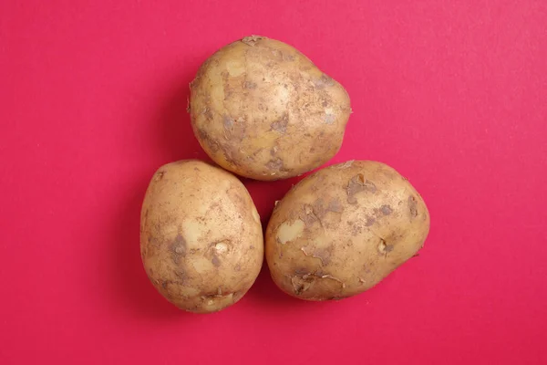 Närbild Potatis Röd Bakgrund Ovanifrån — Stockfoto