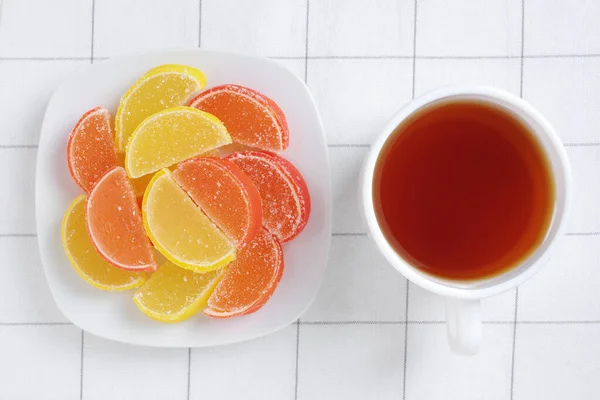 以柑橘类水果片和一杯茶的形式出现在桌子上的果酱 — 图库照片