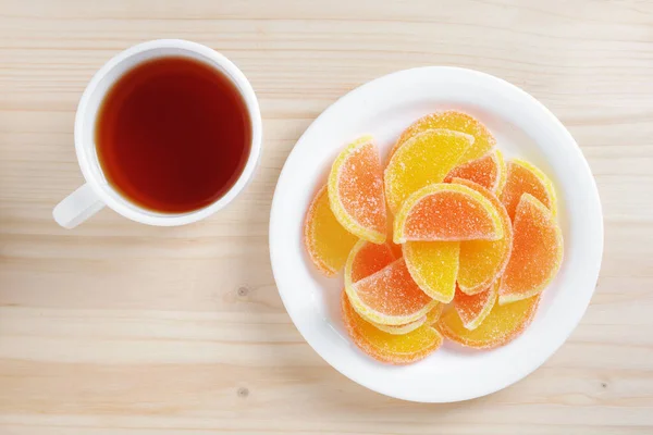 Turunçgil Dilimleri Şeklinde Marmelat Ahşap Arka Planda Bir Fincan Çay — Stok fotoğraf