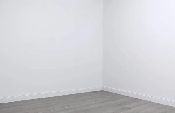 Білі стіни і дерев'яна підлога в кутку порожньої кімнати — стокове фото