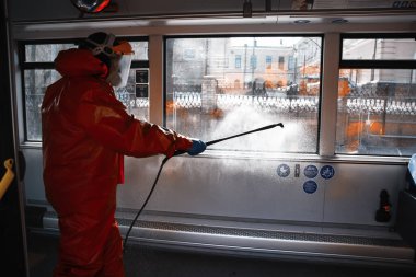 Belediye çalışanı Covid-19 salgını sırasında toplu taşımacılıkta (otobüs) sıvı dezenfekte edici (dezenfekte) sağlarken - Vilnius, Litvanya, Avrupa