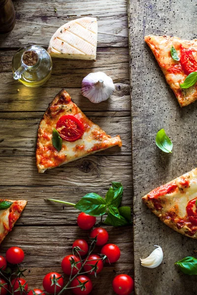 Pizza on wood with ingredients — Stock Photo, Image