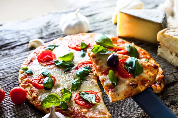 Pizza on wood with ingredients — Stock Photo, Image