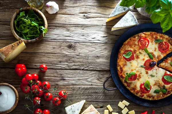 Pizza sobre madera con ingredientes — Foto de Stock