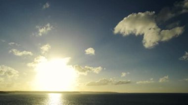 Geniş timelapse ufuk uçurumlarda ve okyanus üzerinde bir günbatımı atış. Küçük bulutlar Güneş ufuktan perspektif izlenim güçlendirilmesi ön plan doğru hareket ediyor. Tarih Pzr metin veya grafik yerleştirmek yararlı büyük alan.
