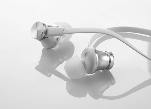 Auscultadores Fones de ouvido em fundo branco reflexivo — Fotografia de Stock