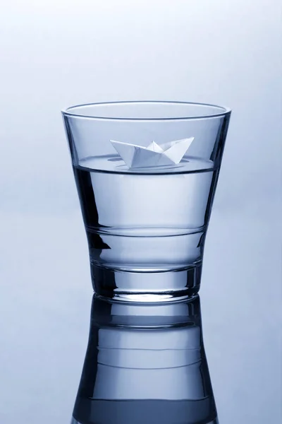 Glass of water with paper origami boat Concept — Stock Photo, Image