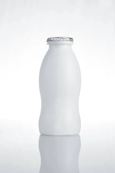 Botella de leche de plástico blanco sobre fondo blanco con reflexión —  Fotos de Stock