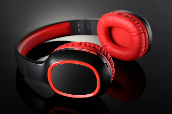 Drahtloses Bluetooth-Kopfhörer-Gadget auf schwarzem reflektierendem Backgro — Stockfoto