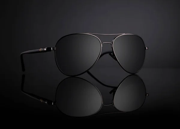 Schwarze Fliegersonnenbrille mit Reflexion auf schwarzem Hintergrund — Stockfoto