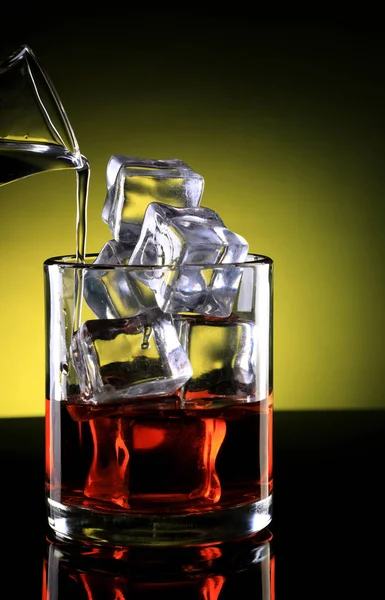 Bicchiere di whisky con cubetti di ghiaccio e bevande versate — Foto Stock
