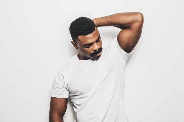 Serious black man with casual outfit posing over white background looking away