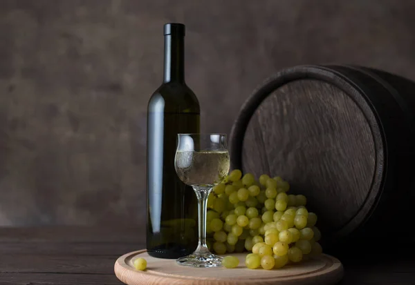 Una bottiglia di vino, un bicchiere di vino, uva e botte — Foto Stock