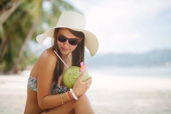 Mulher relaxante em uma praia paradisíaca com coco — Fotografia de Stock
