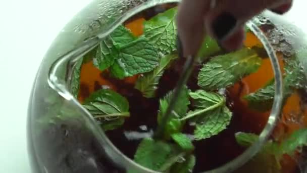 Fille jette des feuilles de menthe dans un thé — Video